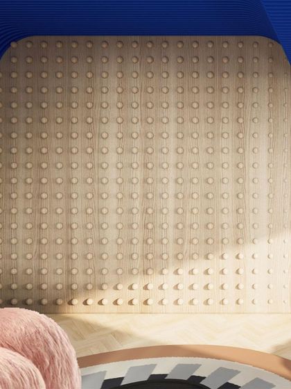A unique wooden wall with protruding dots adds a tactile and graphic element to the lounge space.