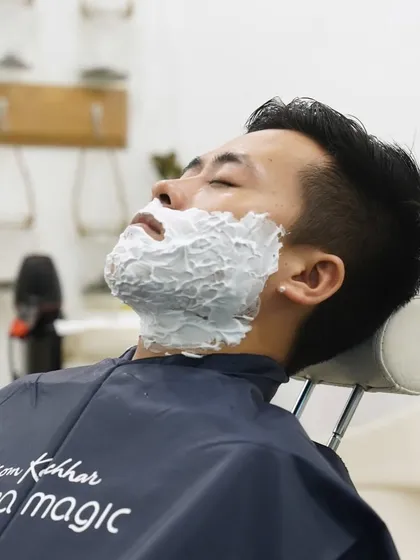A rich, warm lather is applied to soften the beard and protect the skin. This step is crucial for achieving a close yet comfortable shave, allowing the razor to glide effortlessly.