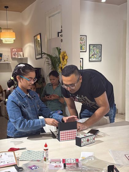 A father and daughter working together on a craft project. Our studio is a welcoming space for families to bond and make lasting memories.