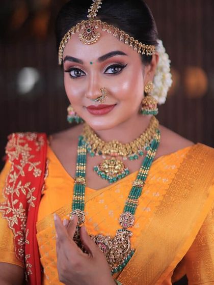 A close-up of a festive look. The bright yellow saree with a contrasting red pallu is perfect for any celebration, and the drape is kept neat to highlight the beautiful colours.