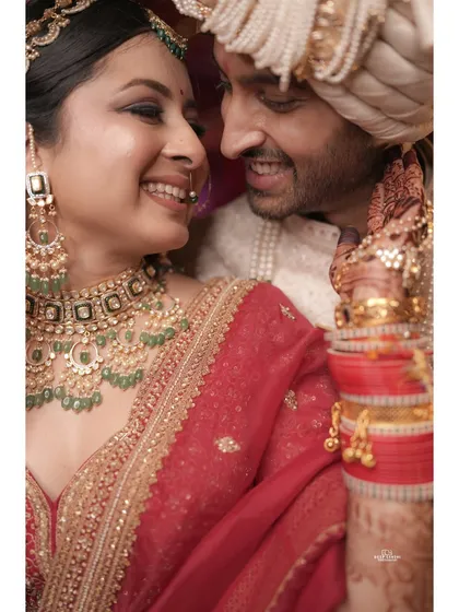A close up shot capturing the joyful smiles and sparkling eyes of the newlywed couple. The bride's Polki jewelry and the groom's happy glance say it all.