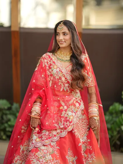 A full-length portrait of the bride, looking confident and beautiful. The soft, flowing hair and glowing makeup are perfect for a modern bride who loves a touch of tradition.