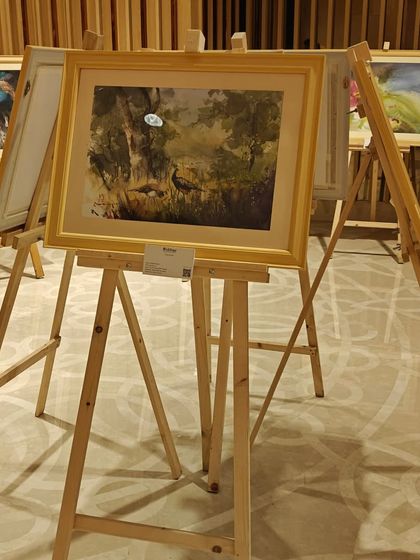A landscape painting by Niladri Ghosh from 'Ethereal Charm', displayed on an easel.