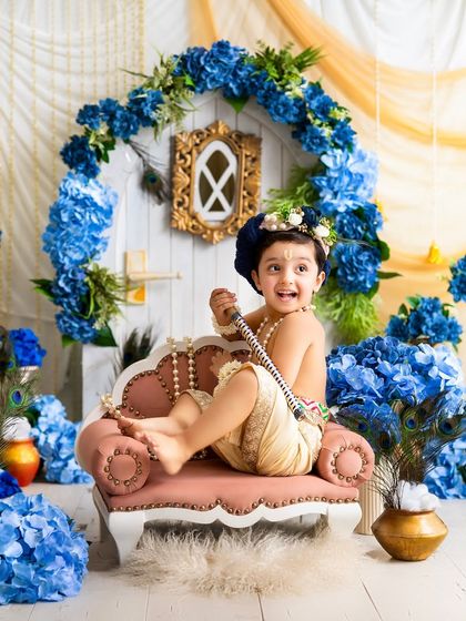 A mischievous and playful expression from our little Krishna. These are the fun, personality-filled shots that parents adore.