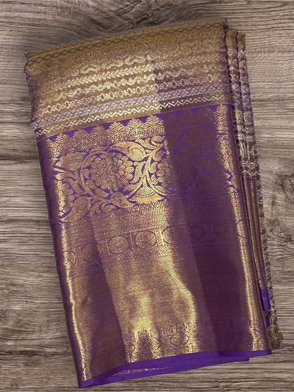 A classic purple Kanchi silk saree with a heavy gold brocade border and pallu.