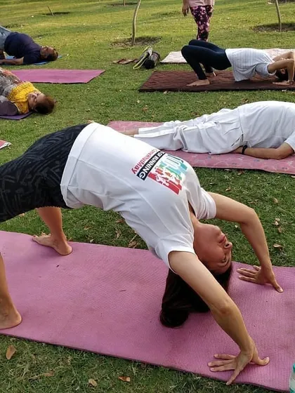 A close-up of a participant in Chakrasana, demonstrating great form and dedication during our outdoor community class.