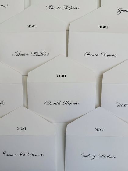 A top-down view of the Dior notecards, showcasing the beautiful layout and the classic combination of black ink on white paper.