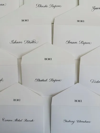A top-down view of the Dior notecards, showcasing the beautiful layout and the classic combination of black ink on white paper.