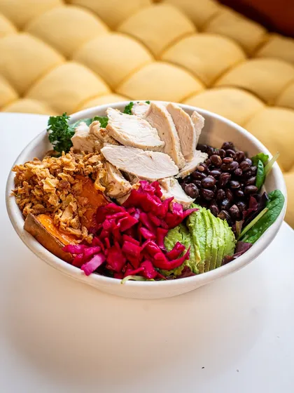 A vibrant and colorful salad bowl, beautifully arranged to show off every ingredient. The bright, clean lighting makes it look fresh and healthy.