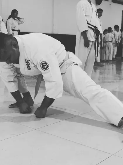 A little progress each day adds up to big results. This image shows a student building strength and conditioning their body through challenging knuckle push-ups.