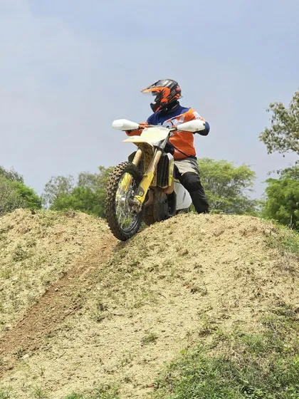 A rider on a Husqvarna dirt bike, ready to take on the next challenge. Our training isn't limited to one type of bike; we help you master the machine you bring.
