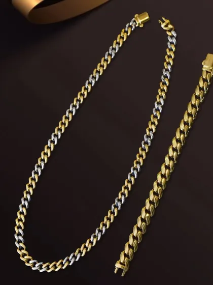 A product shot of a matching two-tone gold chain and bracelet set. I used soft lighting and a simple ribbon prop to create a sophisticated look for this jewelry combo.