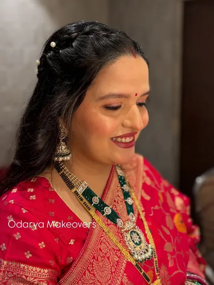 A side profile of the naming ceremony look, showing the soft makeup and the simple, elegant hairstyle with pearl accents.