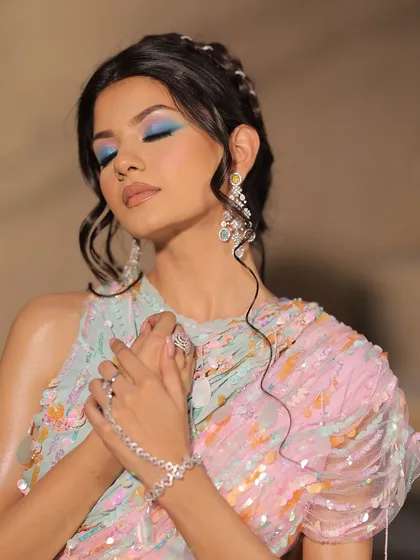 Eyes closed to showcase the solid, vibrant blue eyeshadow in this carnival look.