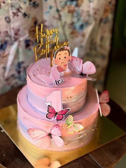 This adorable two-tier cake was made in just 1kg for a first birthday. It features a soft pastel palette and is decorated with delicate, edible butterflies.