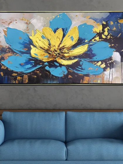 A large, abstract lotus flower in vibrant blue and yellow dominates this hand-painted canvas. The bold colors and gold foil accents make it a powerful and modern interpretation of a classic symbol.
