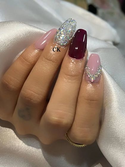 A gorgeous coffin-shaped set with a mix of mauve, deep red, and full silver glitter nails, accented with rhinestones.