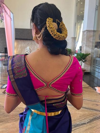 The back of the pink blouse features a stylish strap design, adding a modern touch to the traditional outfit.