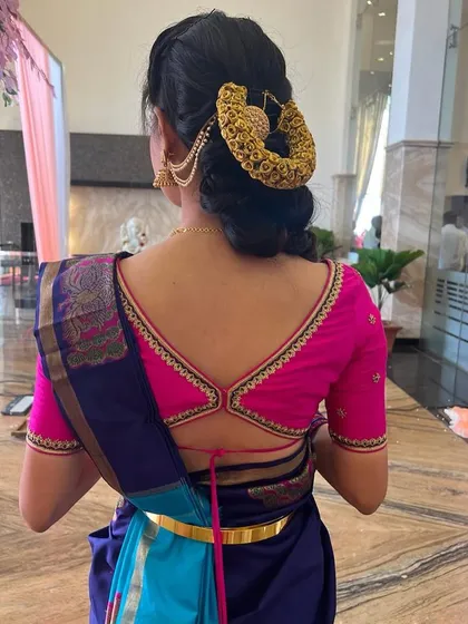 The back of the pink blouse features a stylish strap design, adding a modern touch to the traditional outfit.