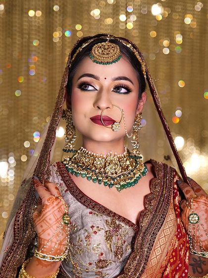 A classic bridal look with a modern twist. This bride wears a beautiful pastel lehenga contrasted with a traditional red dupatta, with makeup that is both timeless and fresh.