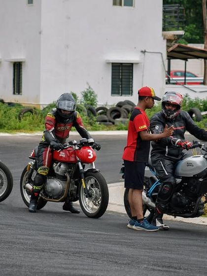 A coach demonstrates correct bike handling and positioning during a drill. We use a hands-on approach to ensure every rider understands the physical mechanics of controlling a motorcycle at speed.