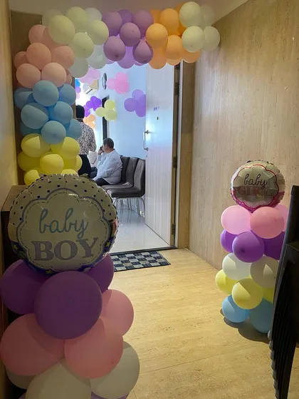 The entrance to the welcome party, decorated with pastel balloon pillars and foil balloons.