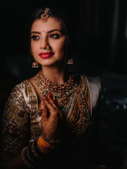 For this classic South Indian bridal look, I used a bold red lip to complement the traditional white and gold saree. The makeup is designed to be timeless and elegant, perfect for the Muhurtham ceremony.
