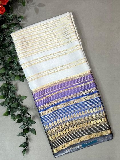 A stunning pure Mysore silk saree featuring a white body with a multi-color Rangkat pallu in shades of purple and blue.