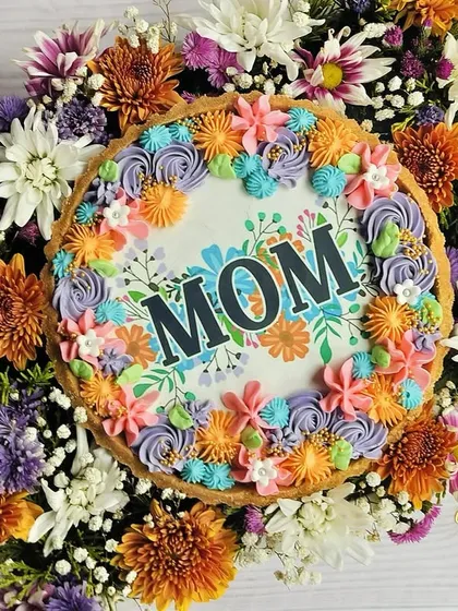 The perfect bouquet for Mom is a sweet one! This is my Mother's Day Chocolate Tart Hamper, featuring a custom 'MOM' tart surrounded by a vibrant bouquet of fresh flowers.