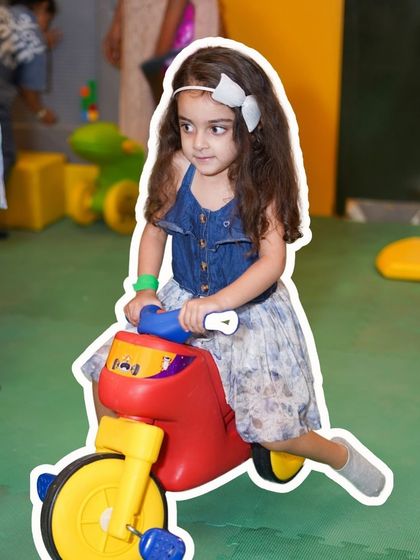 A toddler enjoying one of our many ride-on toys. We have a dedicated area with age-appropriate toys for our youngest guests.