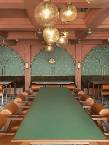 The dining area features arched niches with floral wallpaper, inspired by Mughal gardens. Custom banquette seating and long community tables cater to different group sizes.