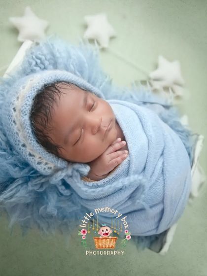 A close-up of this little one, showing the detail of the knitted bonnet and the soft, fluffy layers they are resting on. It's all about comfort and coziness.