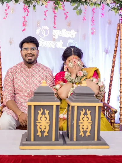 A candid moment of laughter and shyness during a baby shower game. The mother-to-be covers her face playfully while her partner laughs, capturing the genuine, unscripted joy that makes these events so special.