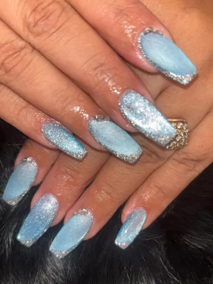 A beautiful "ice queen" look with these coffin-shaped nails. They feature a light blue base with a sugar glitter effect and silver glitter tips for a frosty, sparkling finish.