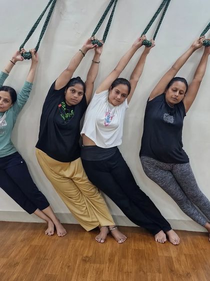 A group of students using the rope wall for a side-body stretch. This is a great way to lengthen the torso and improve lateral flexibility as a group.