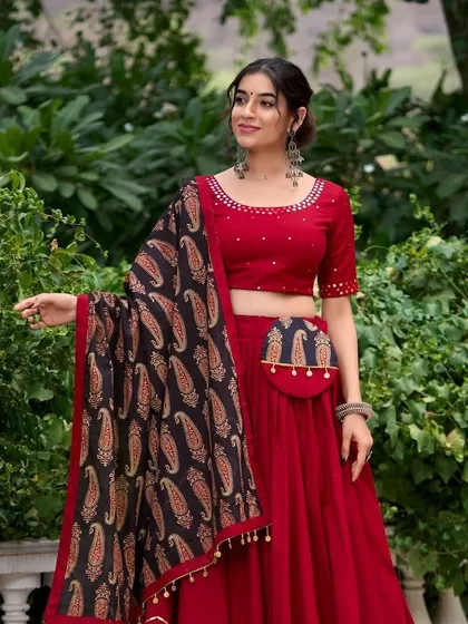 This red lehenga comes with a cute matching potli (pouch), so you can keep your essentials safe while you dance. It’s a stylish and practical detail.