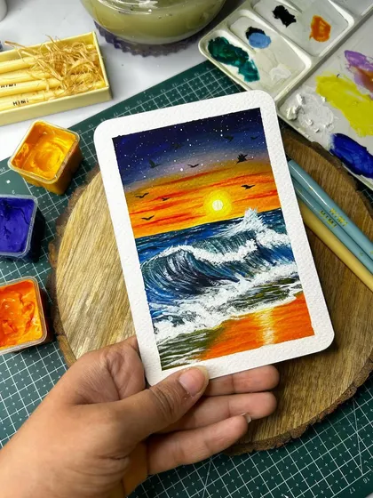 Holding the sunset Polaroid painting to show its handheld size. These mini paintings are perfect for decorating your desk or gifting.