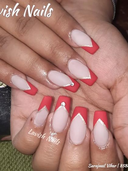 A sharp V-shaped French manicure in matte red, outlined in silver and accented with a single rhinestone.