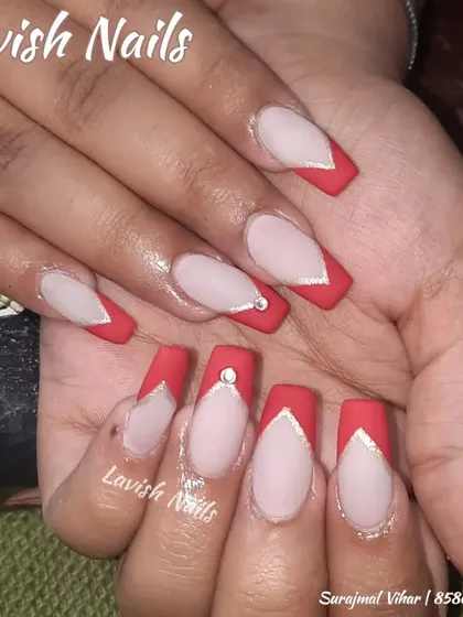 A sharp V-shaped French manicure in matte red, outlined in silver and accented with a single rhinestone.