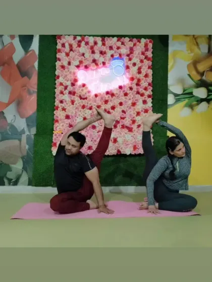 Partner yoga helps in achieving deeper stretches and building trust. This image shows an advanced seated spinal twist and leg extension pose, demonstrating incredible flexibility.