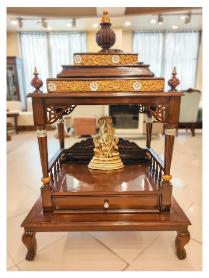 This handcrafted pooja mandir is made from solid teak wood with a rich walnut finish. The design features traditional carving details and a tiered shikhara, creating a serene and sacred space in your home. I can customize the size and details to fit your specific needs and traditions.