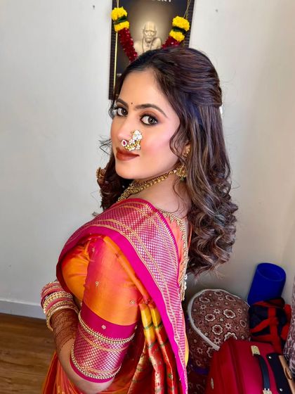 A beautiful shot of the bride looking over her shoulder, showing off her traditional nath and elegant hairstyle.