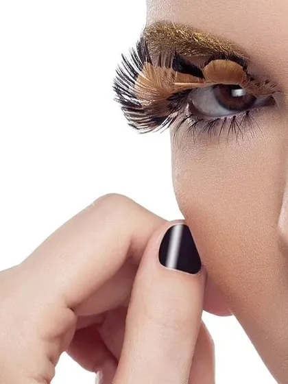A detailed close-up of the creative makeup look, focusing on the feather eyelash and the perfectly manicured nail. This type of shot is crucial for showcasing the work of a makeup artist.