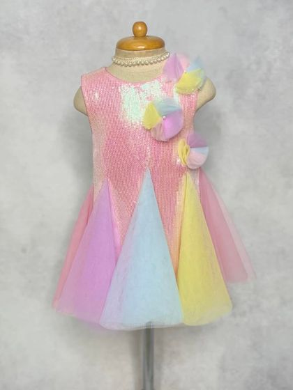 The "Pari" dress in pink sequins with pastel rainbow tulle. This version is perfect for a unicorn or rainbow-themed party, combining sparkle and color.