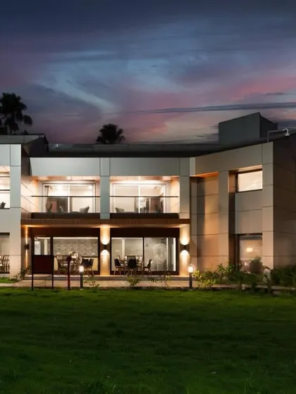 This is the result of our transformation project for the JNPT guesthouse. The architectural design features clean lines, expansive glass, and strategic lighting to create a striking and welcoming presence, especially at twilight.