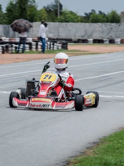 Our driver Mihir Avalakki crosses the finish line, hand raised in victory, after a dominant performance in Round 1 of the Rotax Indian Championship.
