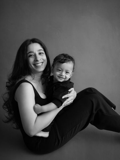 A beautiful and candid black and white portrait of a mother and her smiling baby. The simplicity of monochrome really highlights their expressions and connection.