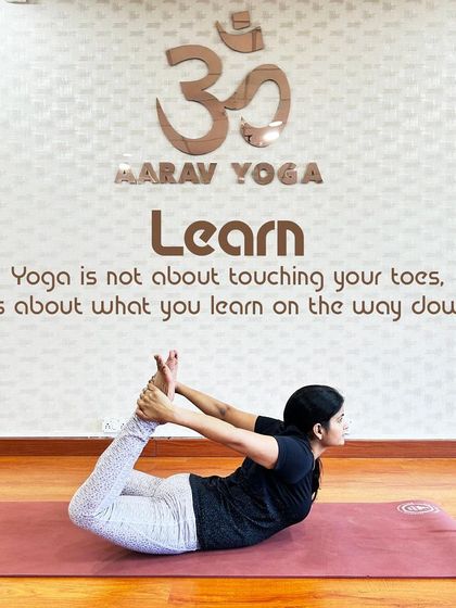"Yoga is not about touching your toes, it's about what you learn on the way down." This image of a practitioner in Dhanurasana (Bow Pose) at our studio embodies our philosophy of focusing on the journey, not just the destination.