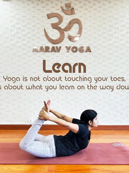 "Yoga is not about touching your toes, it's about what you learn on the way down." This image of a practitioner in Dhanurasana (Bow Pose) at our studio embodies our philosophy of focusing on the journey, not just the destination.