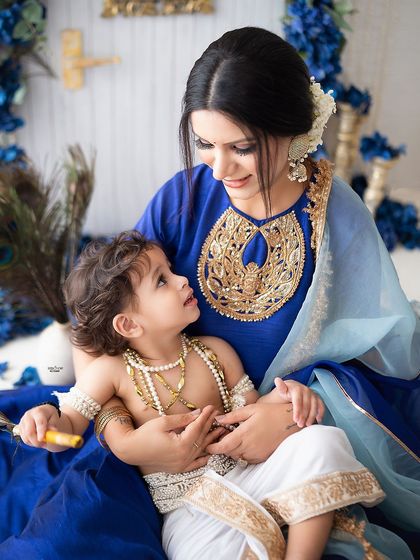 A mother and son share a loving gaze in this beautiful blue-themed Janmashtami portrait.